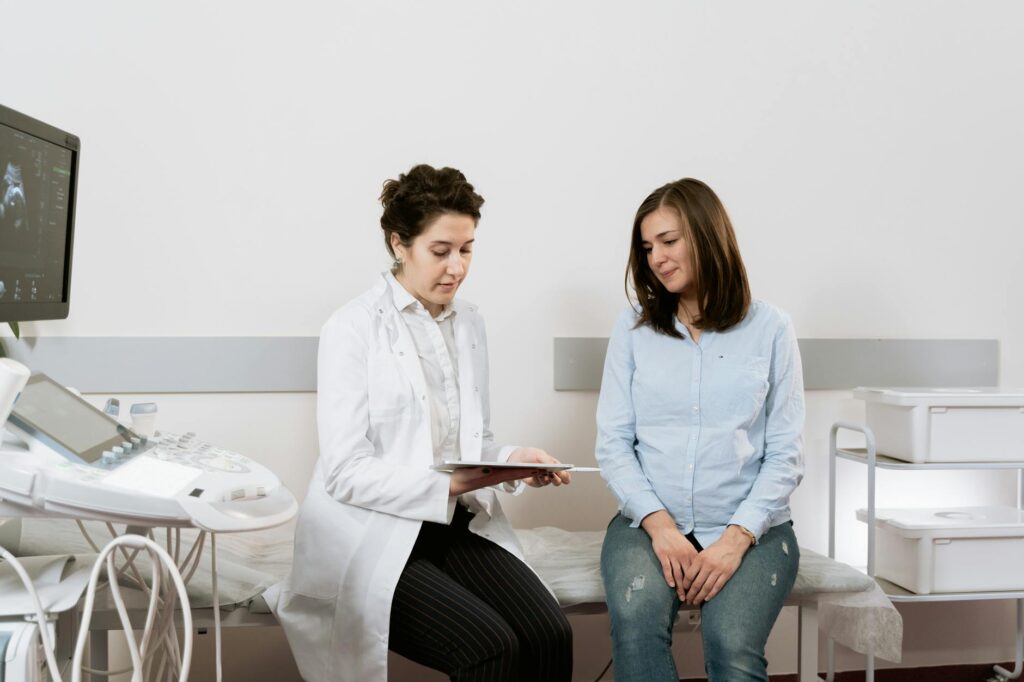 Gynécologue tenant un modèle anatomique d'utérus lors d'une consultation médicale