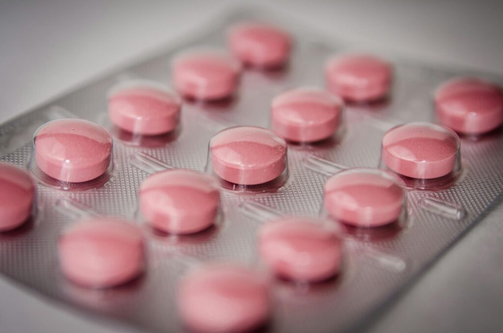 Comprimés médicament gynécologique fond blanc pilulier endométriose traitement hormonal
