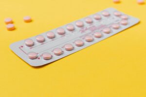 Femme tenant une plaquette de pilule contraceptive d'urgence dans une pharmacie
