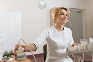 Femme allongée en consultation gynécologique, échographie utérine en cours