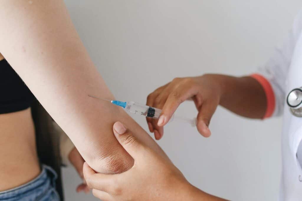 professionnel de santé insérant un implant contraceptif sous-cutané dans le bras d'une patiente