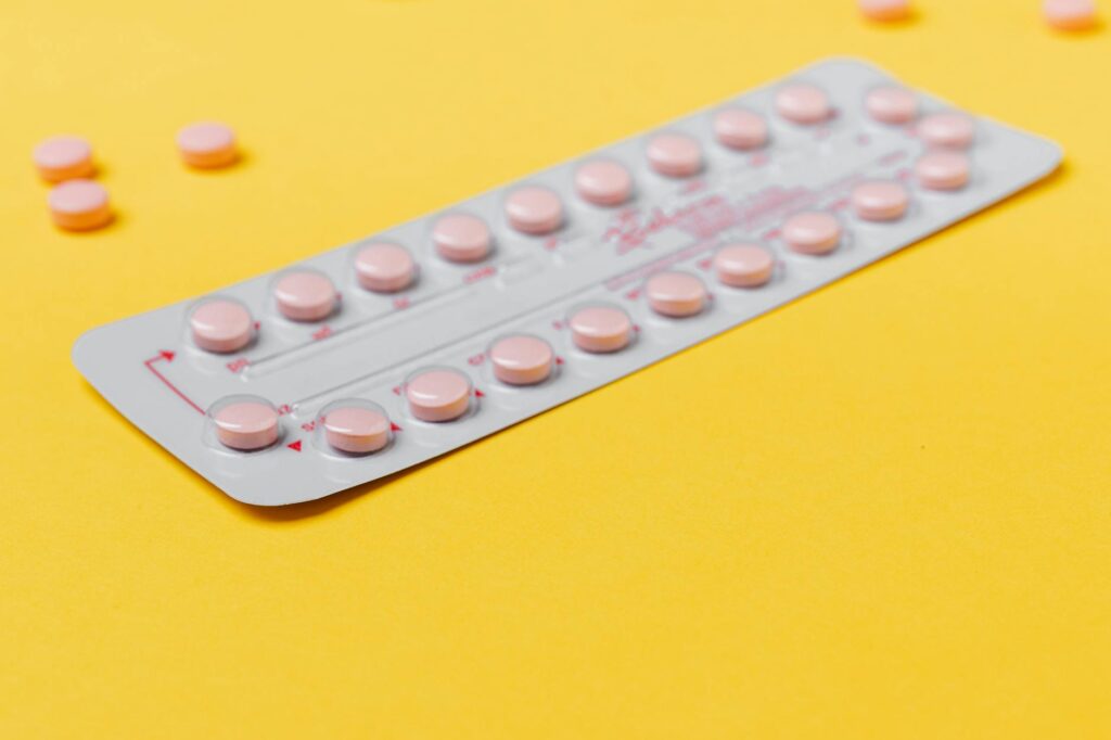 femme tenant un blister de pilule contraceptive progestative près d'un calendrier menstruel
