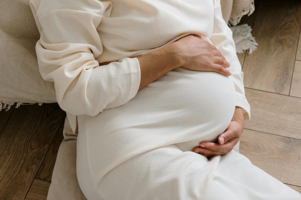 femme enceinte au troisième trimestre allongée tenant son ventre douloureux