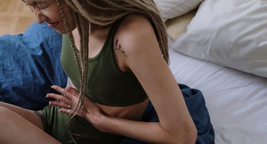 Femme appliquant une poche de froid sur la zone pelvienne pour soulager les douleurs