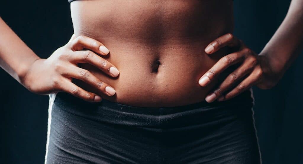Femme allongée avec bouillotte sur le ventre pendant ses règles douloureuses