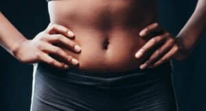 Femme allongée avec bouillotte sur le ventre pendant ses règles douloureuses