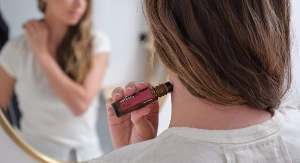 Flacon d'huile essentielle posé sur un bas-ventre féminin avec serviette chaude