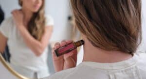 Flacon d'huile essentielle posé sur un bas-ventre féminin avec serviette chaude