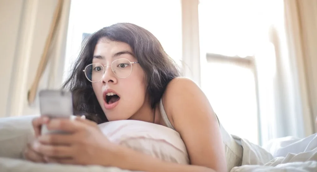 Femme adulte sur lit, main au bas-ventre, visage interrogatif