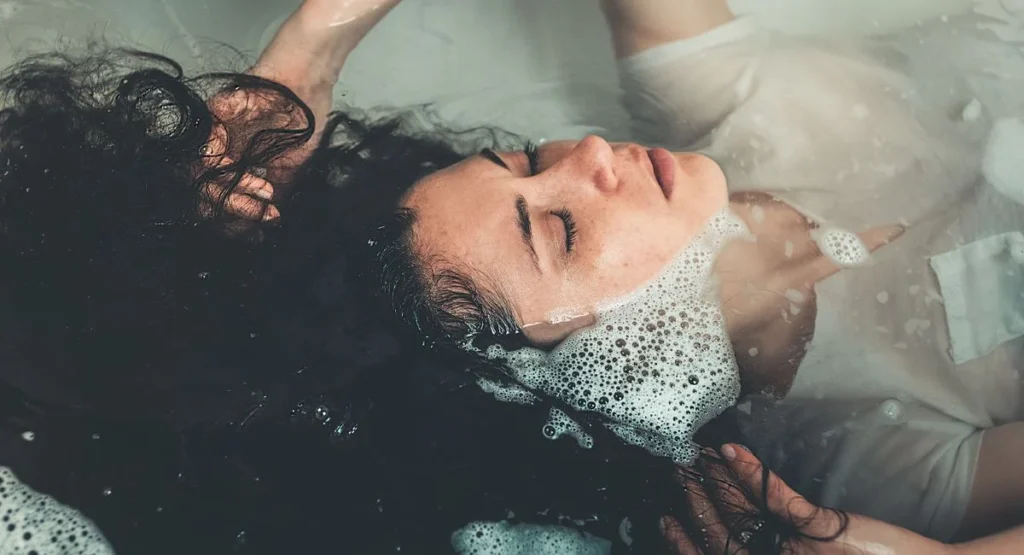 Femme détendue profitant d'un bain chaud dans une salle de bains lumineuse