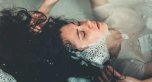 Femme détendue profitant d'un bain chaud dans une salle de bains lumineuse