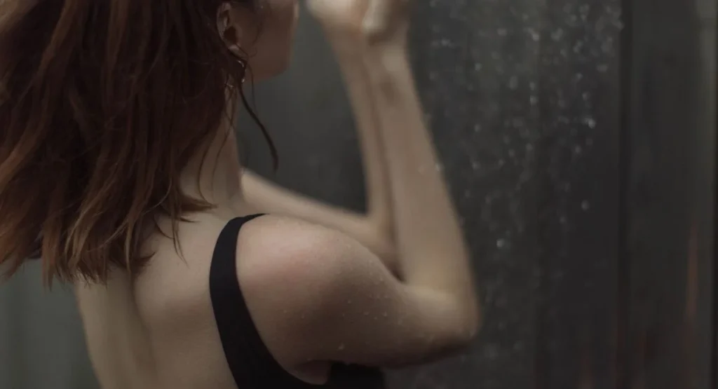 Femme inspectant un pommeau de douche Hansgrohe en salle de bain moderne