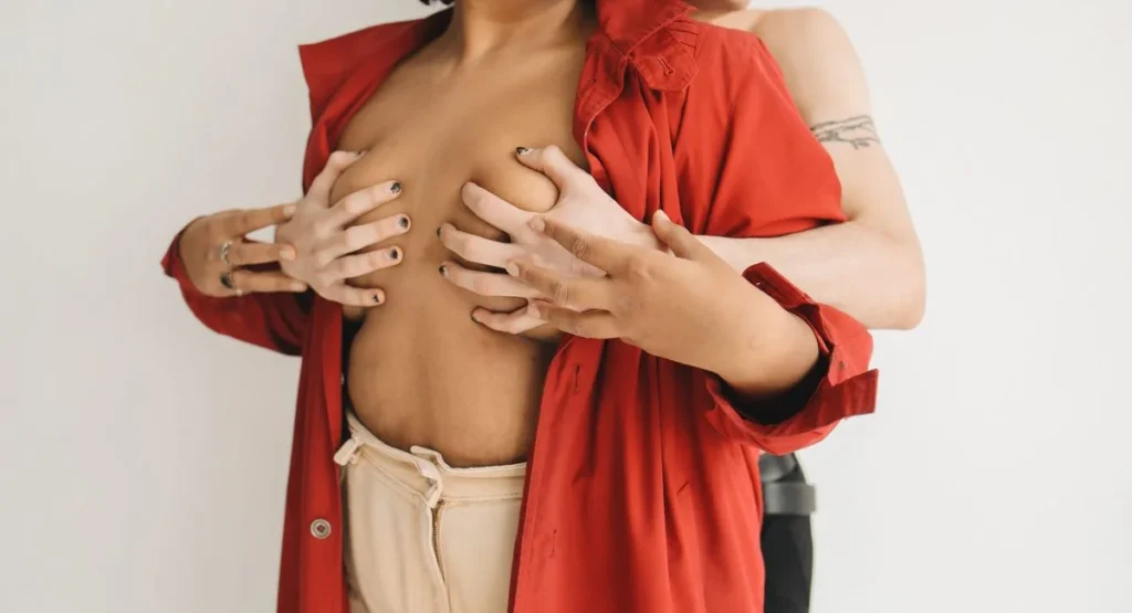 Femme touche son téton en ressentant une gêne, lumière naturelle