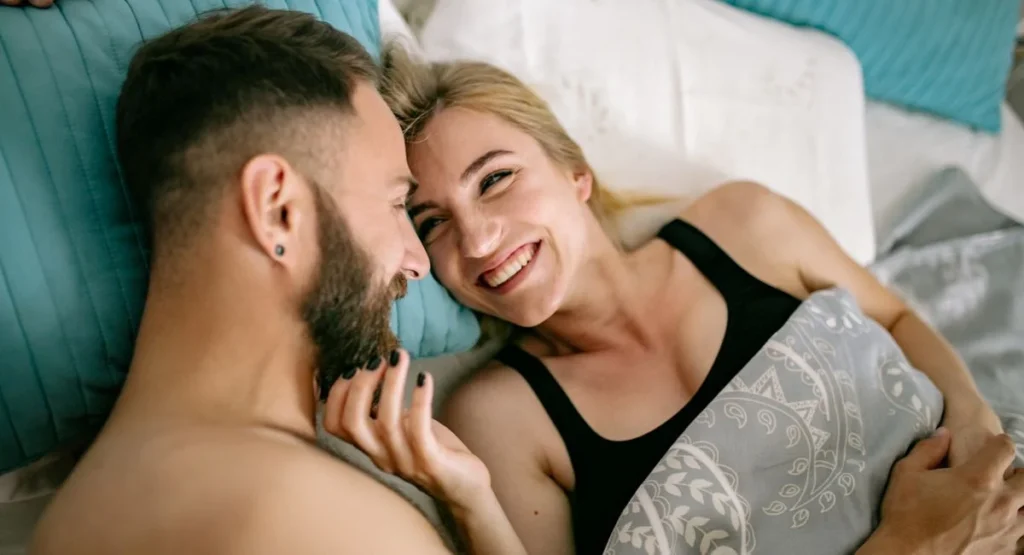 femme yeux fermés, expression de plaisir, allongée sur un lit, ambiance douce