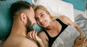 femme yeux fermés, expression de plaisir, allongée sur un lit, ambiance douce