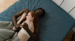 Main féminine tenant clous de girofle au-dessus d’un lit défait