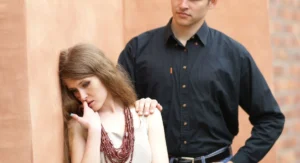 Une femme observe un homme troublé, ambiance intimiste, expression tendue