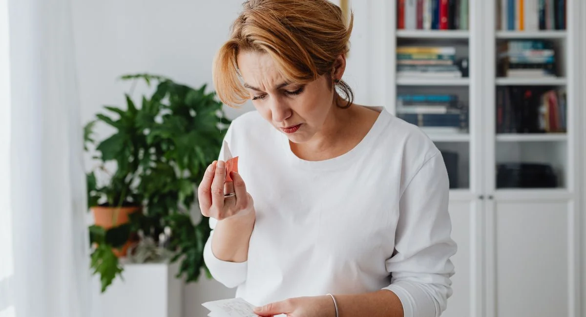 A concerned woman checks her bills, reflecting financial anxiety and budgeting challenges.