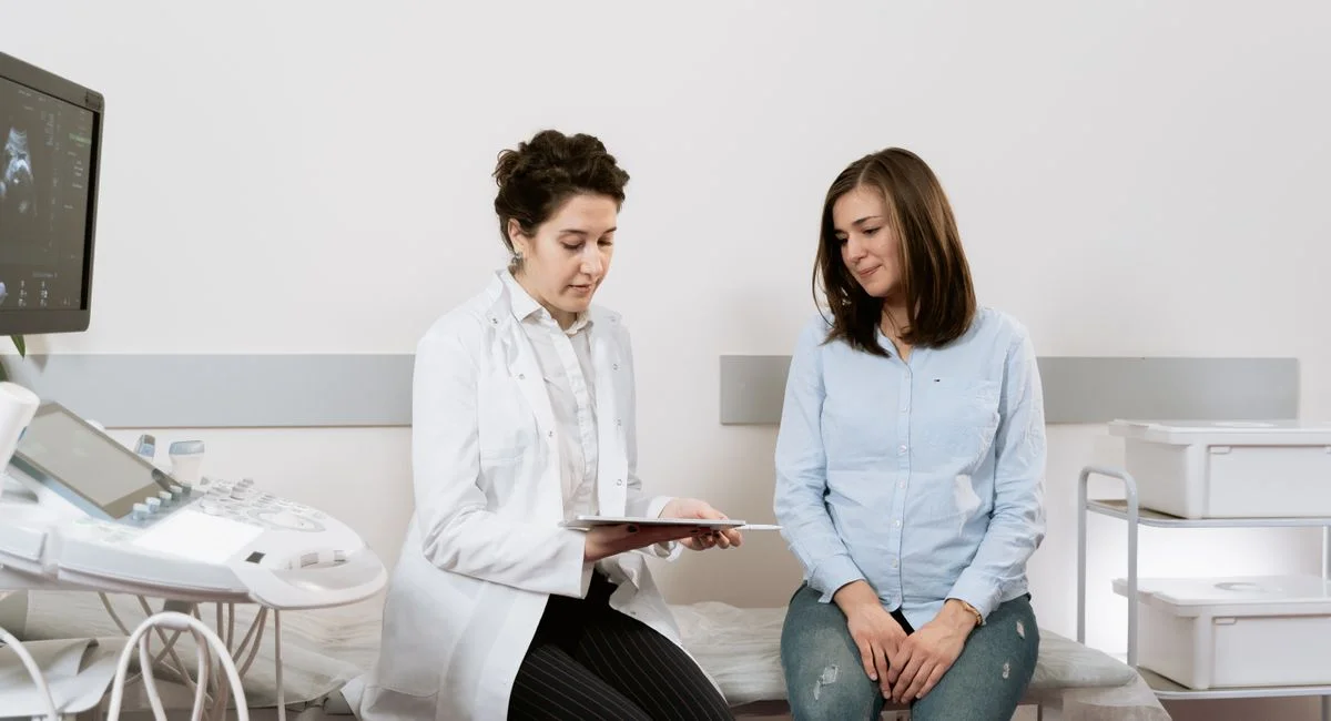 A pregnant woman consulting with a gynecologist in a medical facility.