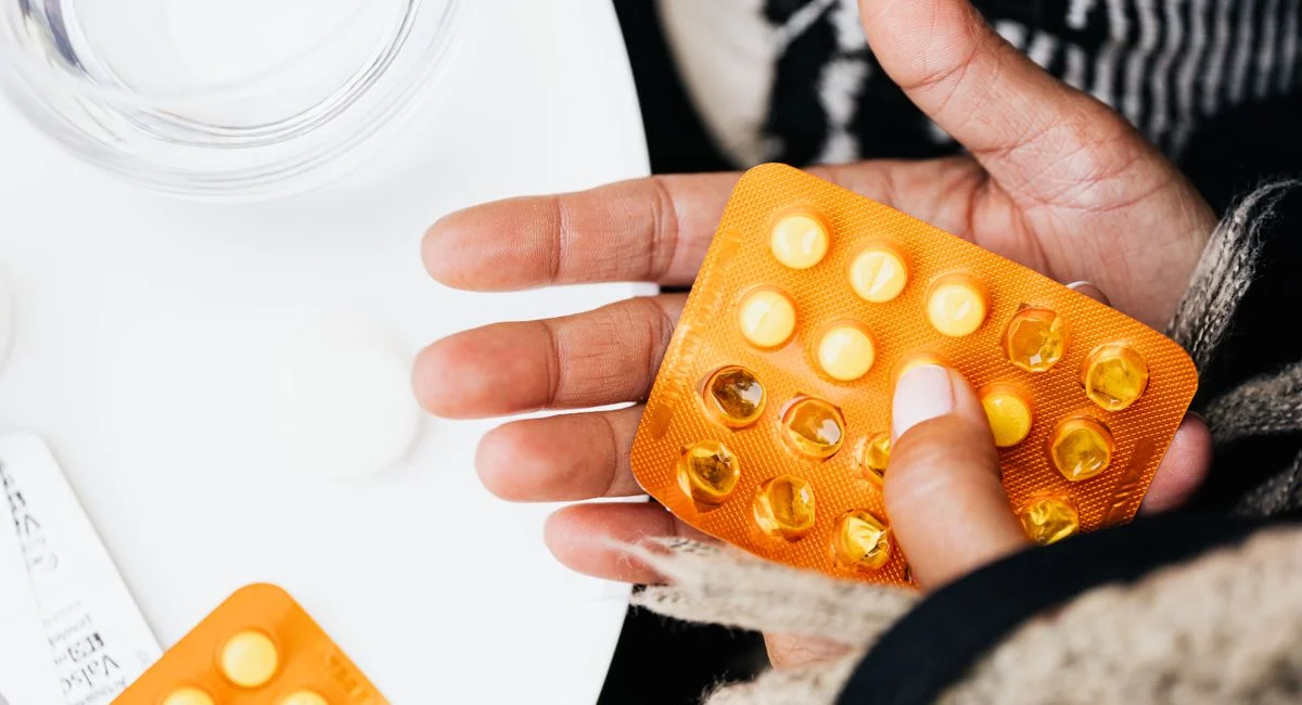 Detailed image of hands holding blister packs of pills, emphasizing healthcare and medicine.