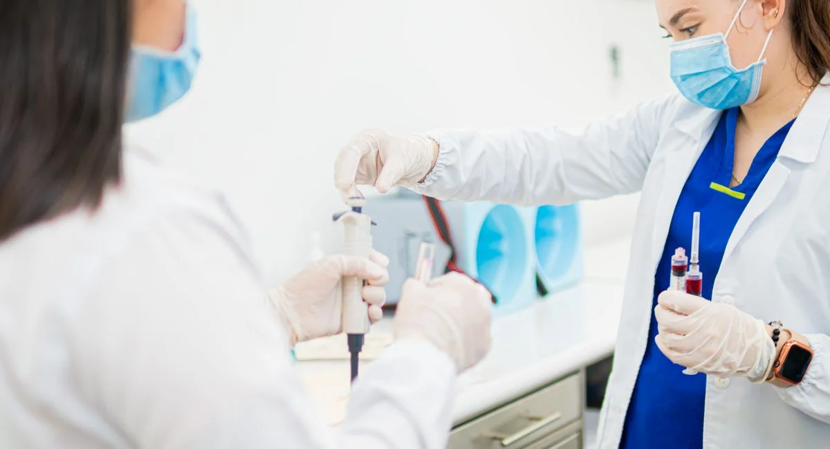 Healthcare professionals performing blood tests in a laboratory setting.