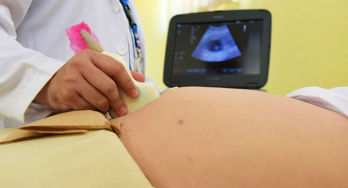 Medical professional conducting an ultrasound on a patient in a clinical setting.